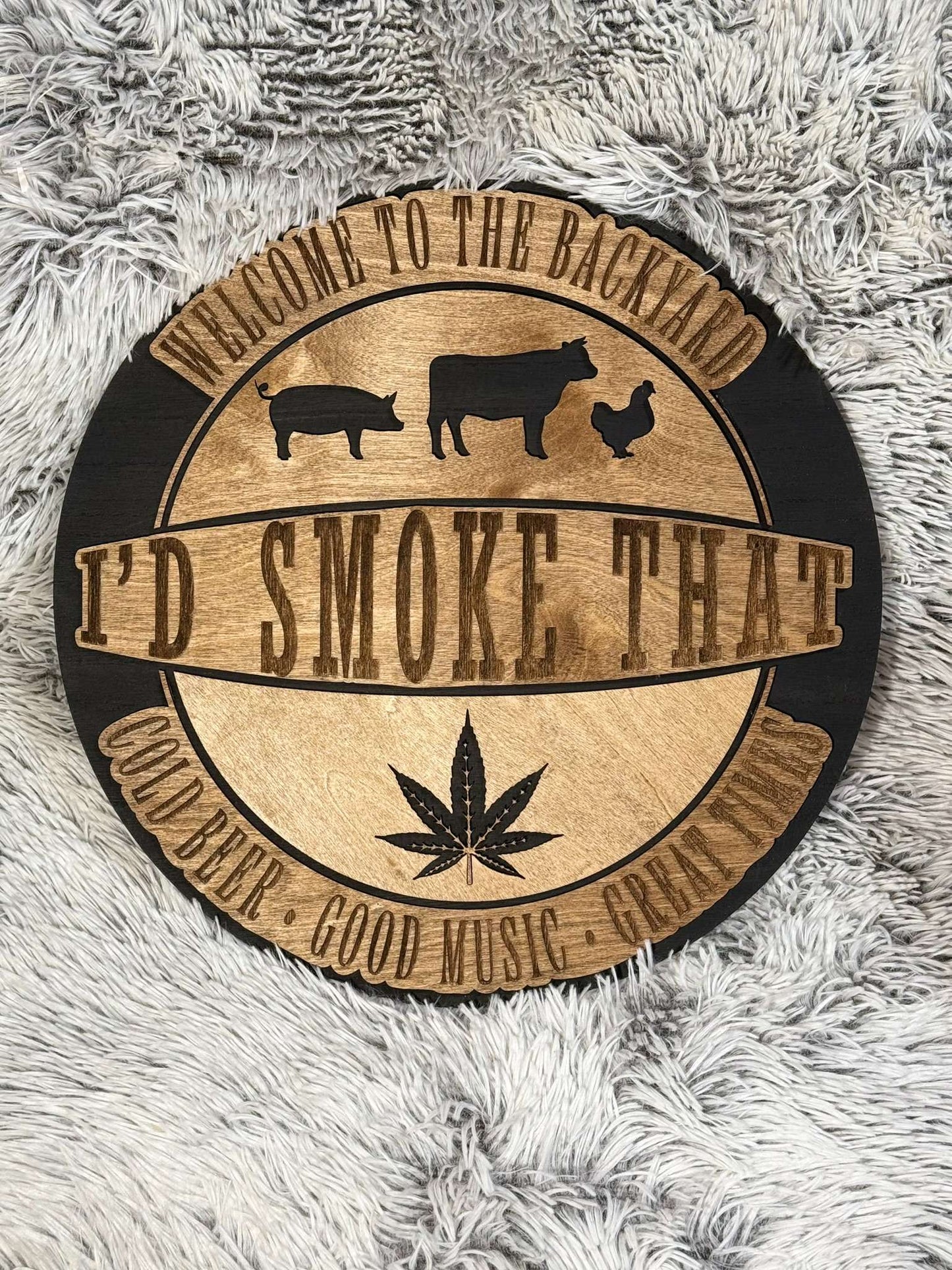 Round sign laser engraved and cut that says I'd Smoke that and has chicken cow pig and weed leaf. Welcome to the back yard, cold beer, good music, great times