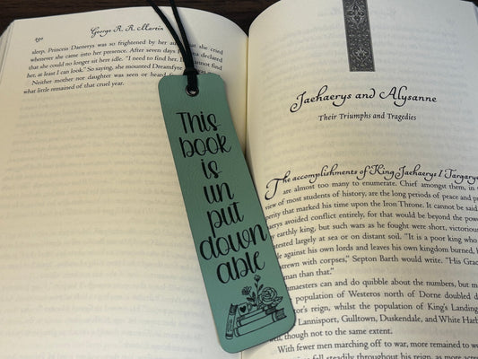 humorous green leatherette faux leather bookmark lying on an open book