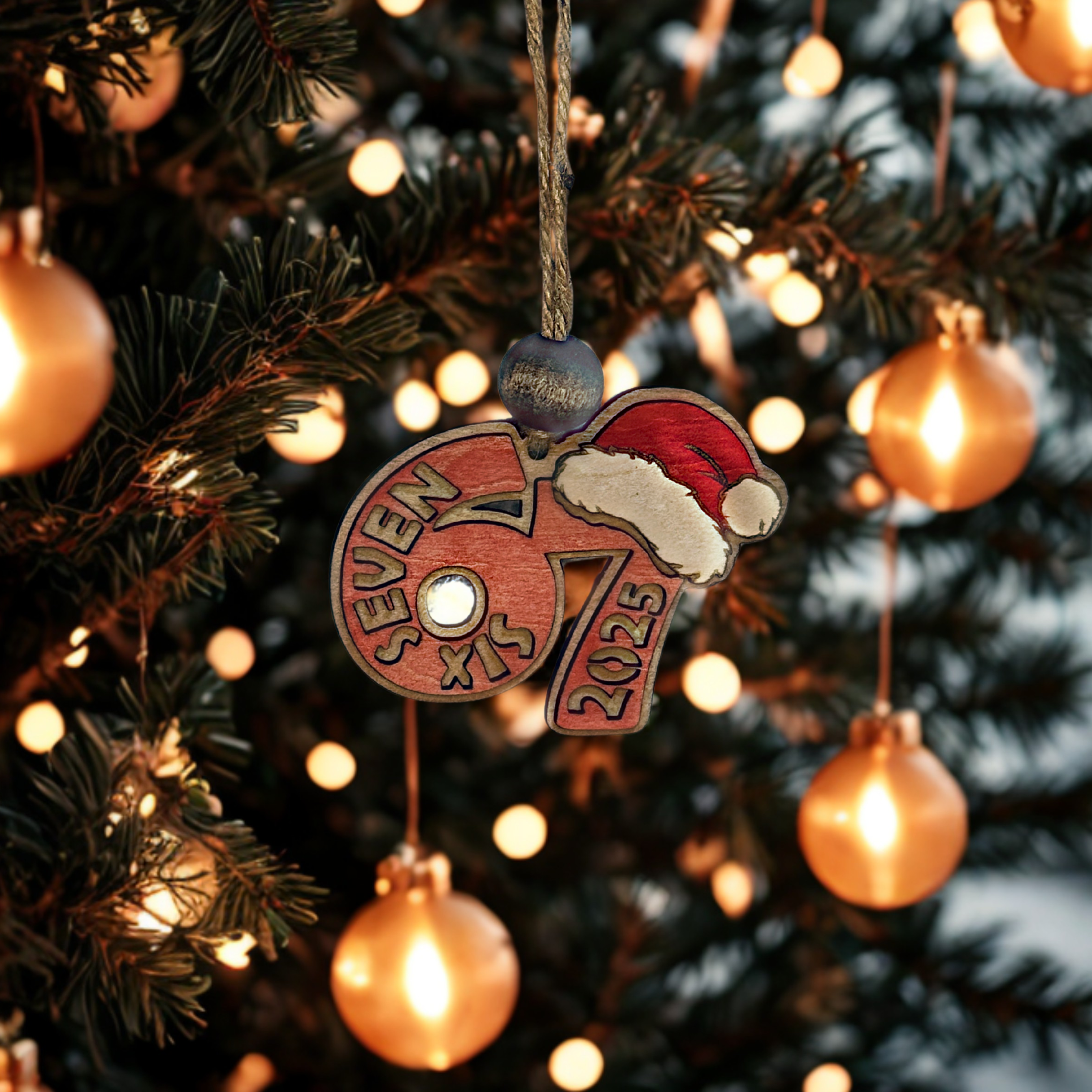 Decorative red ornament with 67 Six Seven 2025 on a Christmas tree with lights.