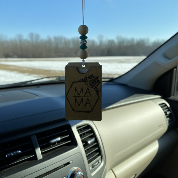Wooden car freshener with engraved mama inside a floral frame hanging from a rearview mirror