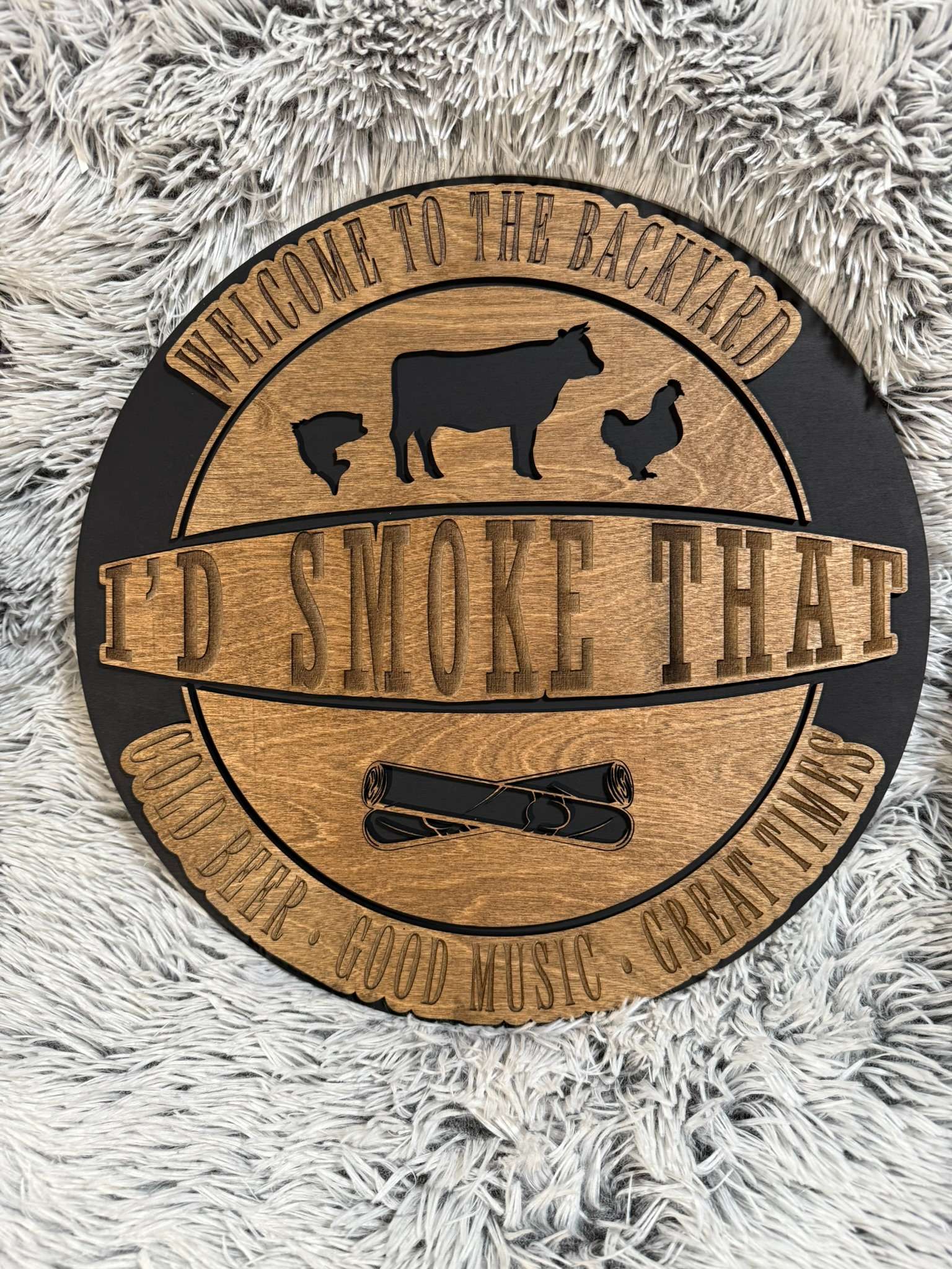 Round sign laser engraved and cut that says I'd Smoke that and has chicken cow fish and cigars. Welcome to the back yard, cold beer, good music, great times