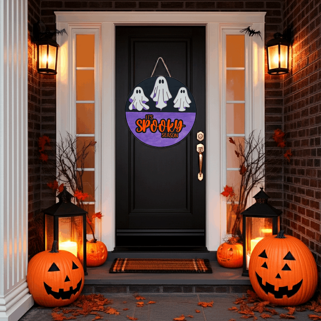 Halloween-themed door decoration with pumpkins and lanterns on a porch.