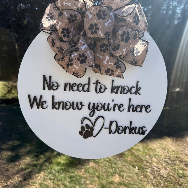 Decorative sign with a paw print design and text on a white background