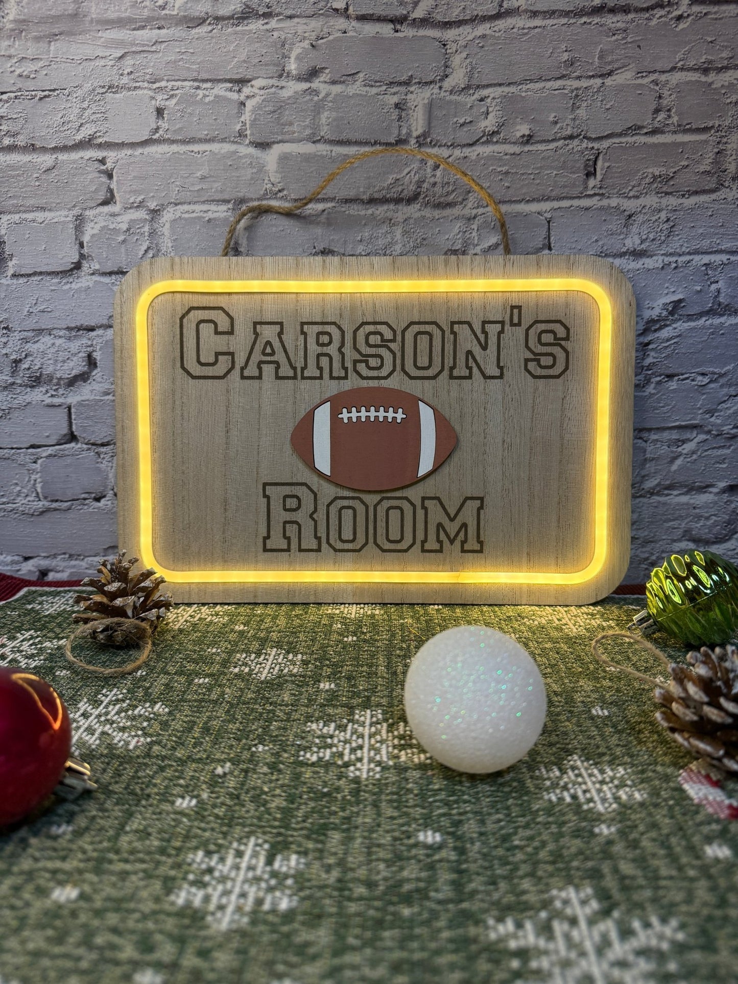 Personalized lighted wood sign laser engraved with a name and a laser cut football with light on