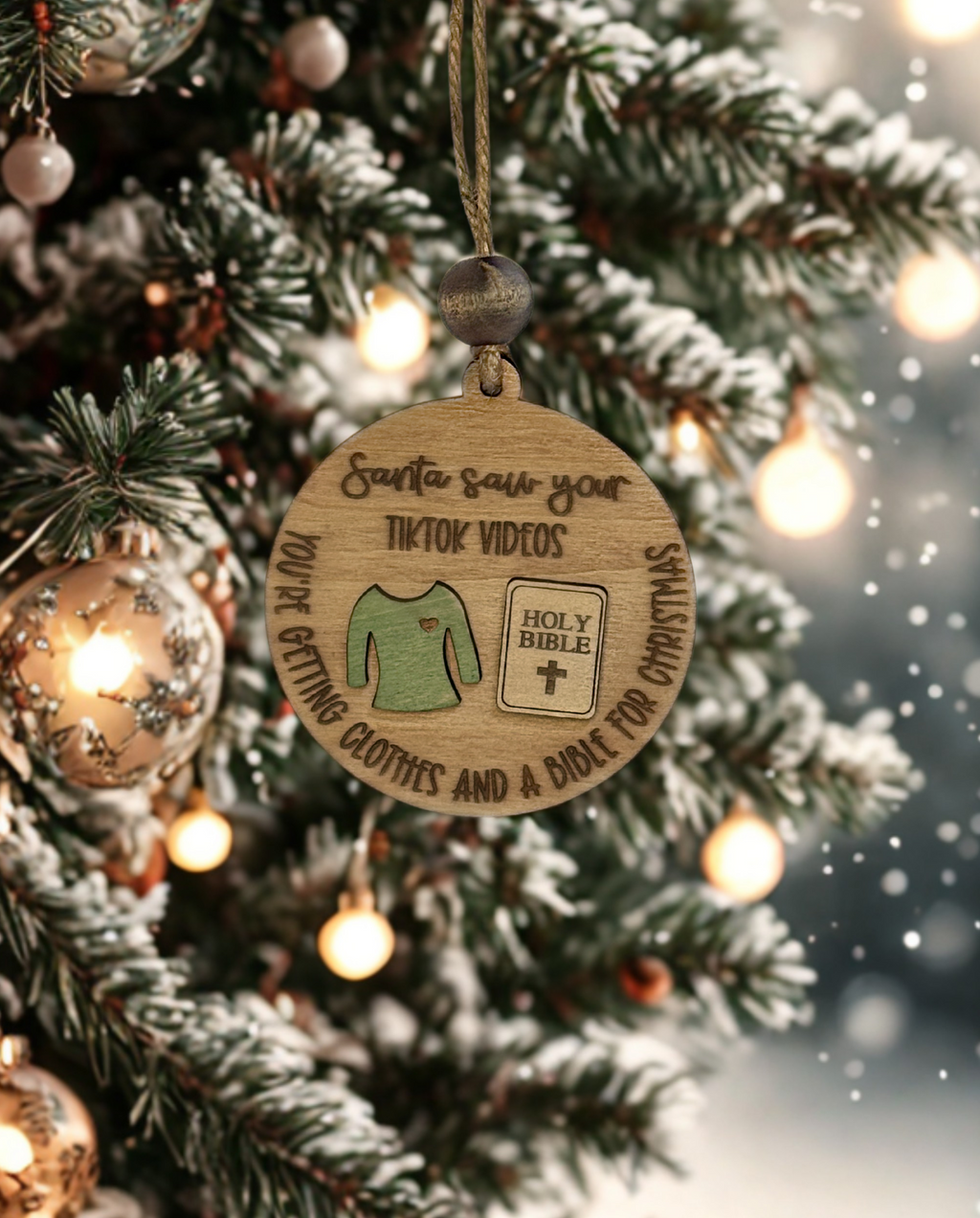 Wooden Christmas ornament with humorous text on a decorated tree