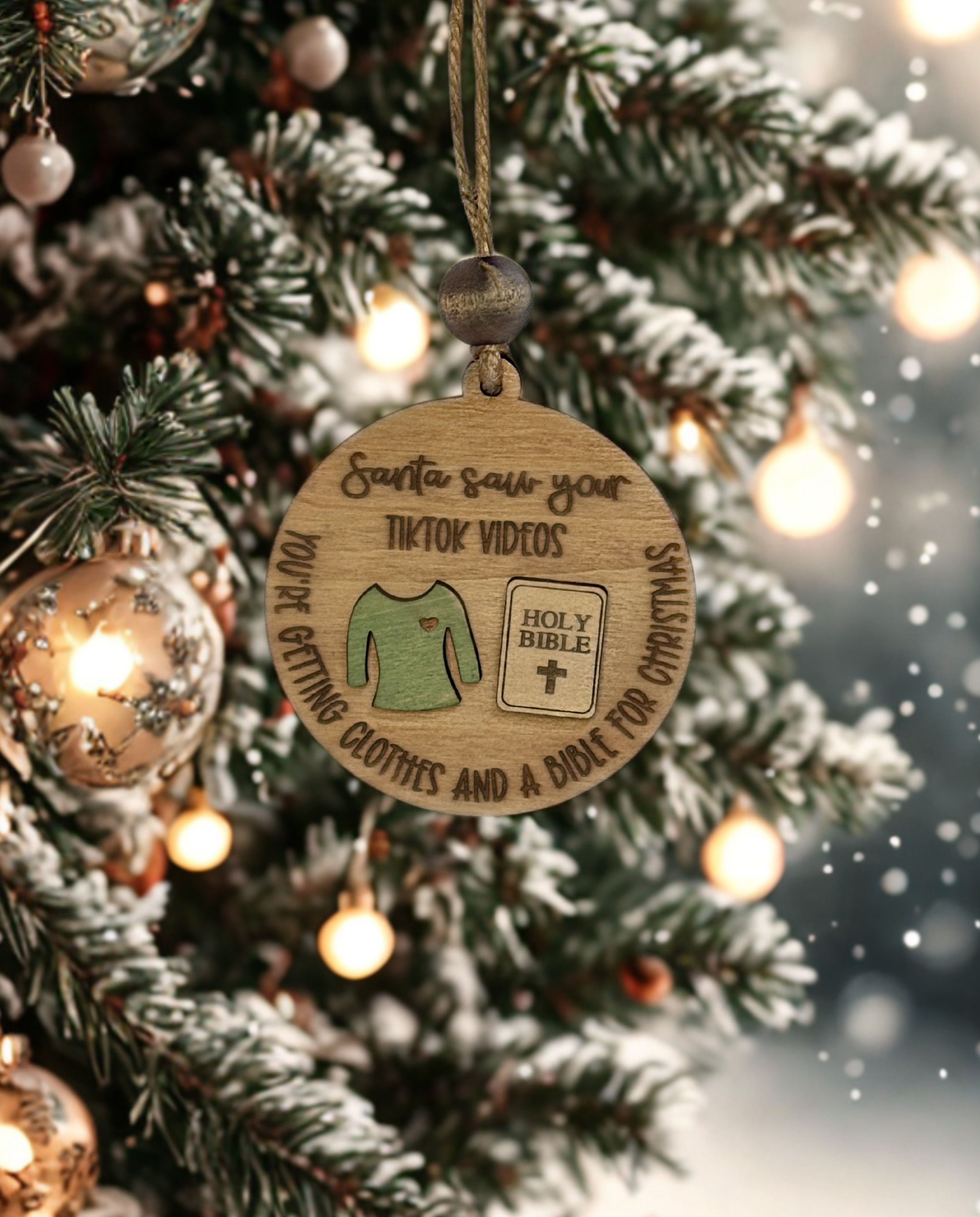 Wooden Christmas ornament with humorous text on a decorated tree