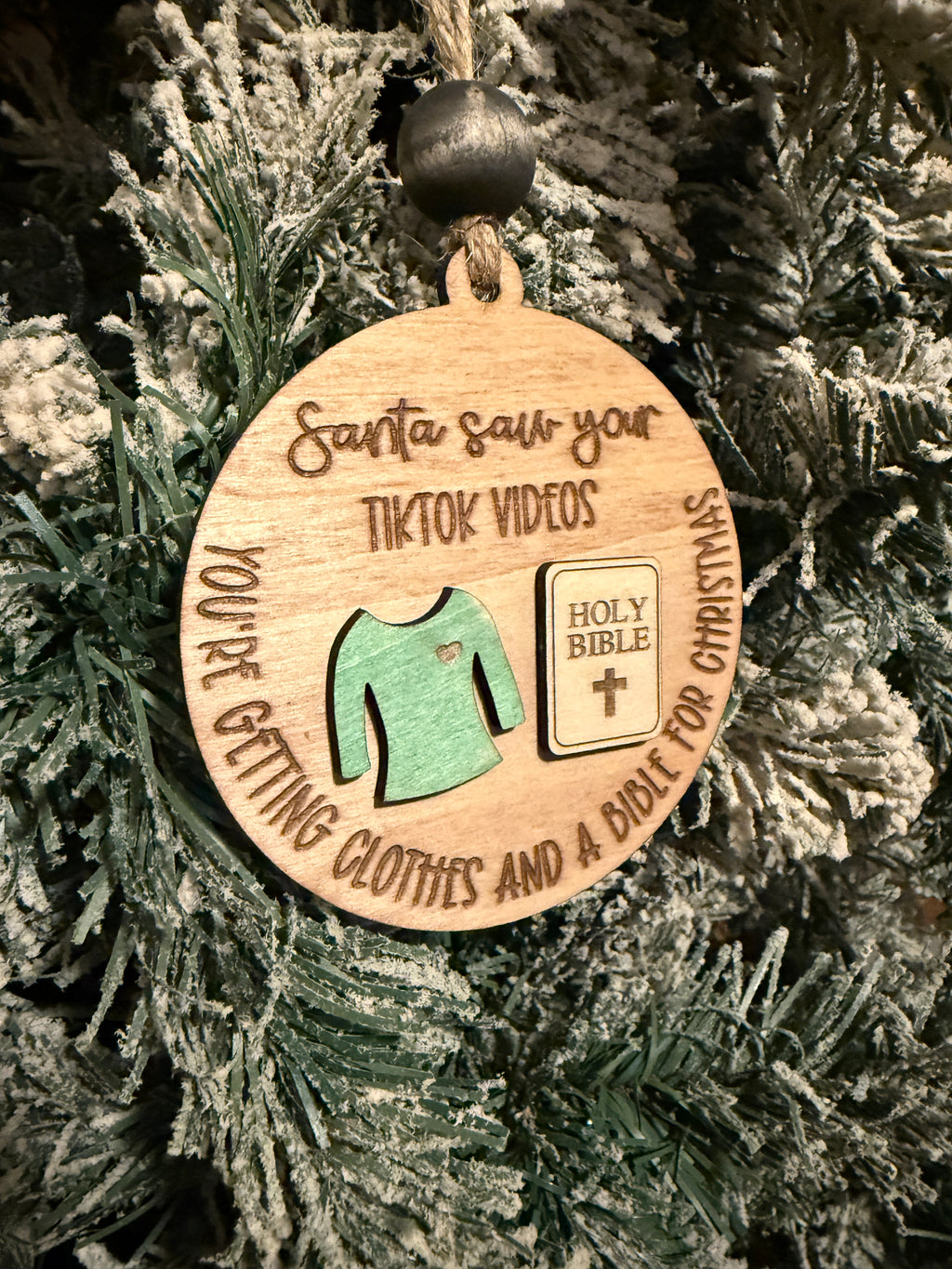Wooden ornament with text and icons on a Christmas tree